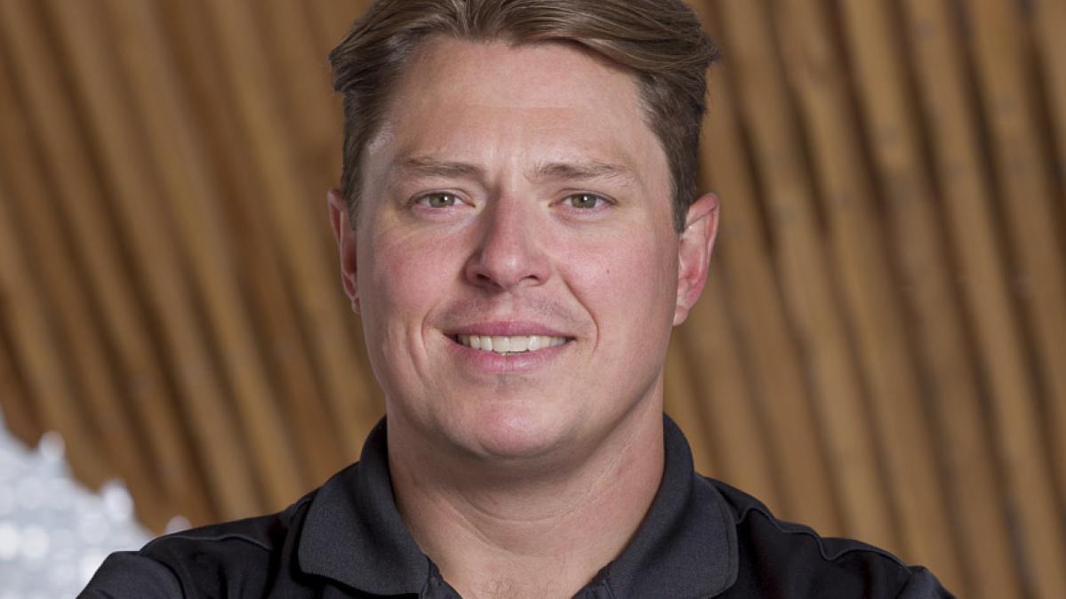A man with short brown hair in a black shirt
