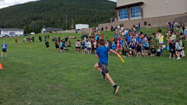 students running relay race, many other students watching
