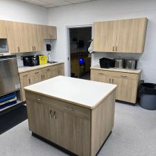 A newly renovated school kitchen with a prep island, new commercial dishwasher and cabinetry.