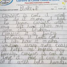 A lined paper with student cursive writing filling part of the page